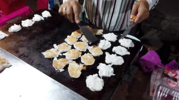 Пхаяо, Таиланд - 2019-03-08 - Продовольственный торговец вращает десертные закуски на плите — стоковое видео