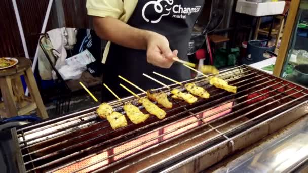 Chiang Mai, Thailandia - 2019-03-15 - I bastoncini di pollo vengono ruotati sul fornello nel mercato — Video Stock
