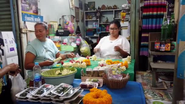 Bangkok, thailand - 2019-03-03 - frauen machen blumenleis, während kunde eine kauft — Stockvideo