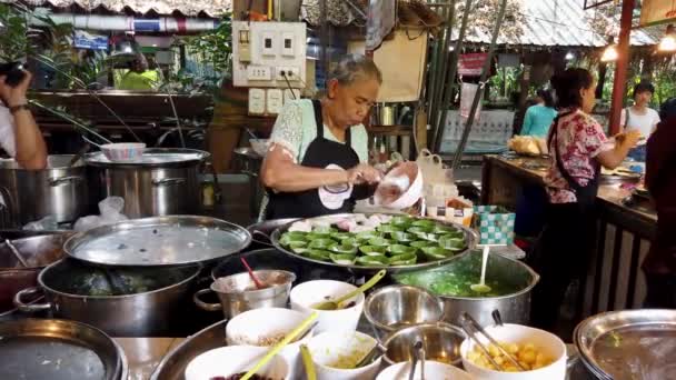 Бангкок, Таиланд - 2019-03-17 - Woman Scoops Pudding Into Leaf Bowls at Market — стоковое видео