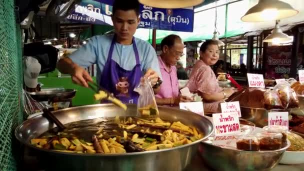 Bangkok, Tailandia - 2019-03-17 - El hombre saca las verduras cocinadas del agua hirviendo y las embolsa — Vídeos de Stock