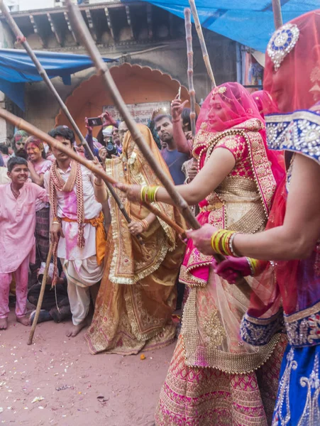 Barsana, indien - 24. februar 2018 - lathmar holi festival - frauen schlagen männer mit bambusstöcken — Stockfoto