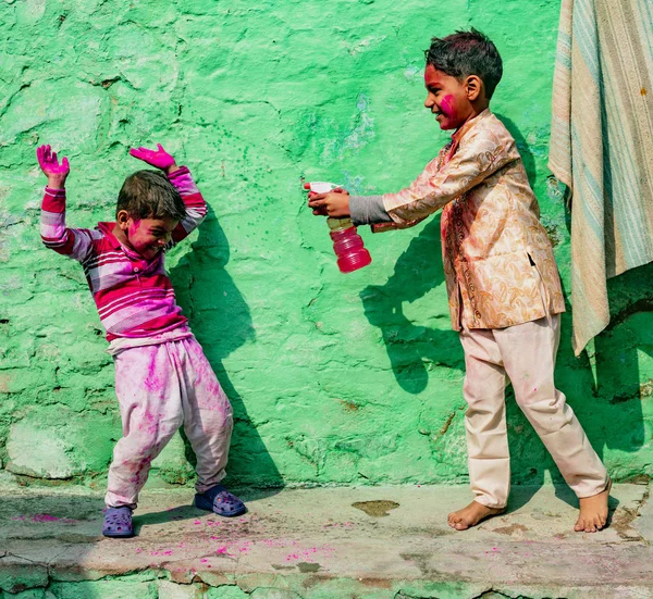 Boy Hindistan 'da renkler Festivali sırasında renk suyu ile kardeşi spreyler