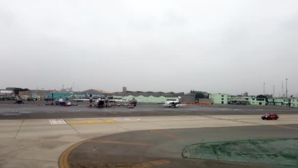 Guayaquil, Ecuador - 2019-06-26 - Vista de la ventana del avión - taxi pasando por embarcaciones pequeñas y militares en el aeropuerto de Gualaquil hacia el despegue — Vídeo de stock