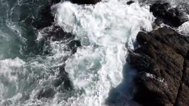 Oceano acqua turbinii tra rocce visto dall'alto come onda arriva — Video Stock