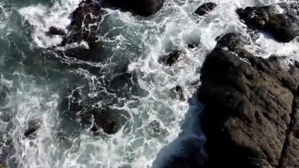 L'acqua dell'oceano turbina tra le rocce viste dall'alto — Video Stock