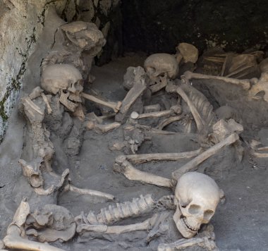 Skulls and bones found entombed in lava clipart