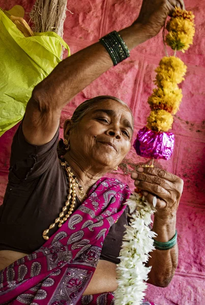 Vrouw creëert bloem leis voor decoratie — Stockfoto