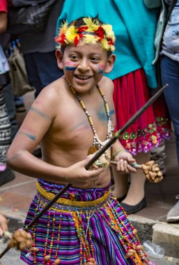 Genç bir çocuk geleneksel yerli kıyafeti giyer.
