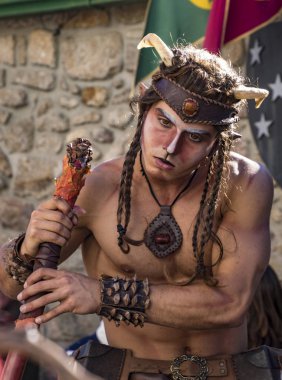 Penedono , Portugal - July 1, 2017 - Man dressed as a satyr gazes with hypnotic inteest at a nearby numph in Medieval fair clipart