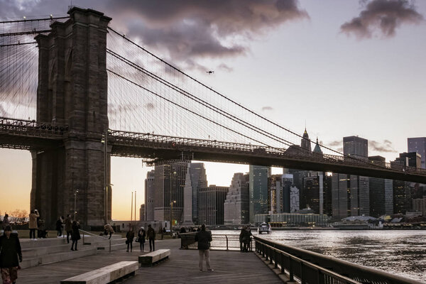 NEW YORK CITY, NEW YORK, MAR 27, 2018: Brooklyn Bridge, seen from Dumbo Park just before sunset