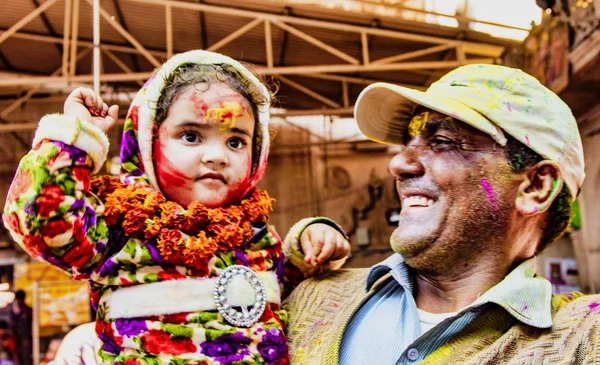 Barsana, India - February 23, 2018 - Man proudly shows his young daughter in Holi festival — Stock Photo, Image