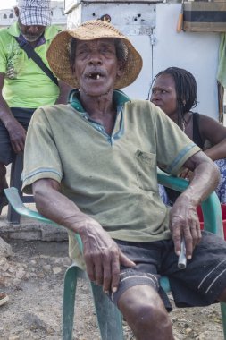 Cartegena, Colombia - December 15, 2015 - Nearly toothless elderly man sits on a chair