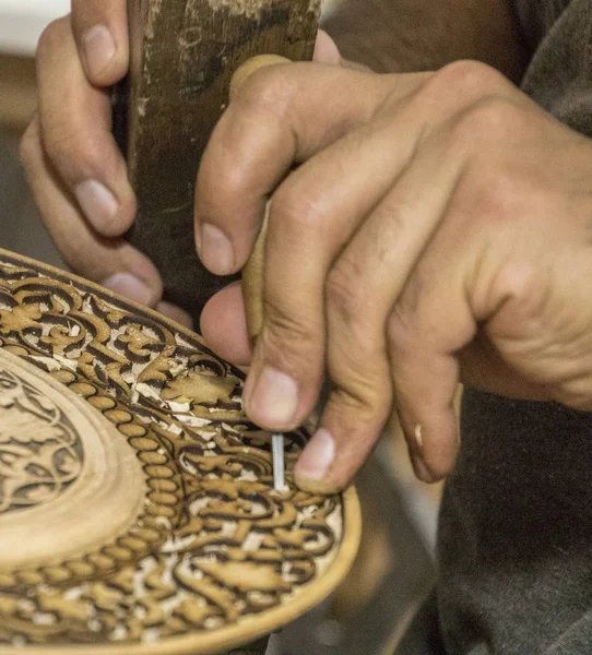 Man chisels wood engraving in workshop near Chorsu Bazaar in Tashken — Stock Photo, Image