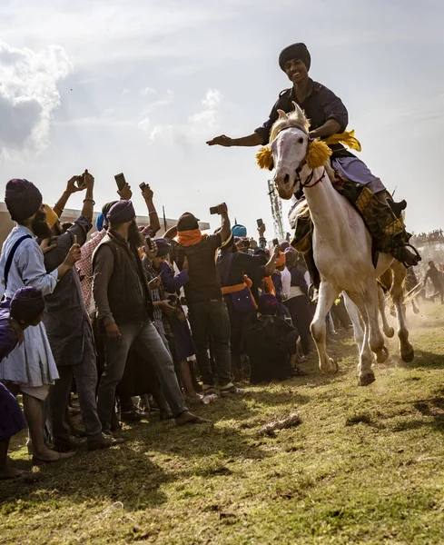 Mann zu Pferd in vollem Galopp, mit allen Hufen in der Luft, rast Zentimeter an Menschenmenge vorbei — Stockfoto