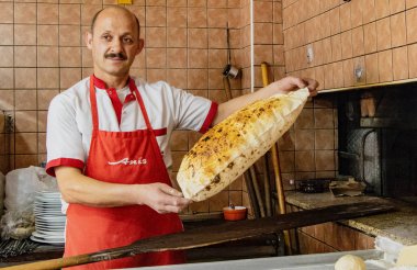 Antalyna, Türkiye - 4 Ağustos 2016 - Baker fırından yeni çıkmış düz ekmeklerle hava atıyor