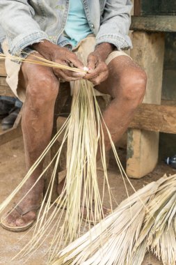 Kadın turistlere satmak için sepet dokuyor.