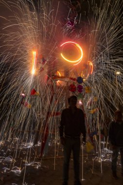 Adam havai fişek şatosunun önünde duruyor.