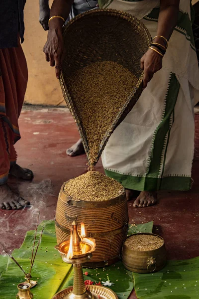 Mujer vierte grano en la cesta como ofrenda al templo hindú — Foto de Stock