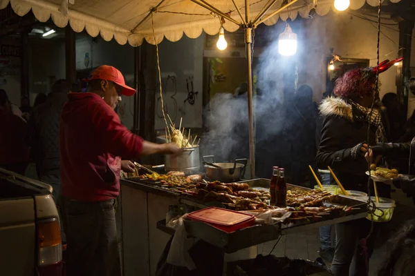Vendedor de comida callejera prepara shish kabob de salchichas, pollo y patatas — Foto de Stock