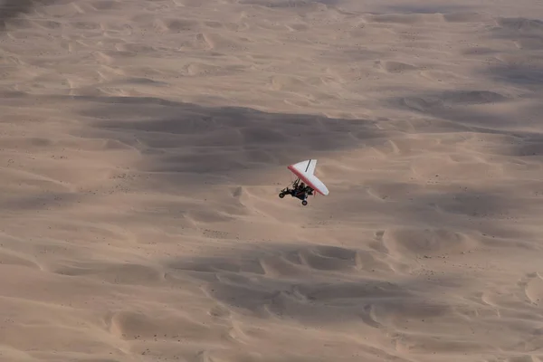 Walvis Bay, Namibia - 16 de julio de 2018: Se ve un avión ultraligero volando con dunas de arena como telón de fondo —  Fotos de Stock