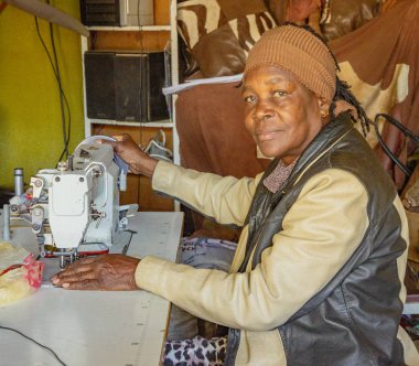 Windhoek, Güney Afrika - 6 Temmuz 2018: Bir terzi küçük bir dükkanda satılık giysiler dikti