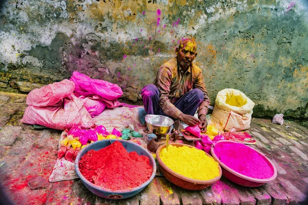 Barsana, India - February 23, 2018 - A man sells paint powder to be thrown by revelers in Holi festival — Stock Photo, Image