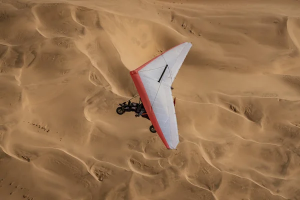 Walvis Bay, Namibia - 16 de julio de 2018: Se ve un avión ultraligero volando con dunas de arena como telón de fondo — Foto de Stock