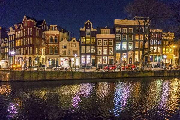 Night view of buildings along Amsterdam canal — Stock Photo, Image