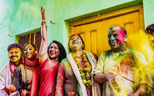 Barsana, India - February 23, 2018 - Indian family laughs while throwing powdered paint into air during Holi festival — Stock Photo, Image