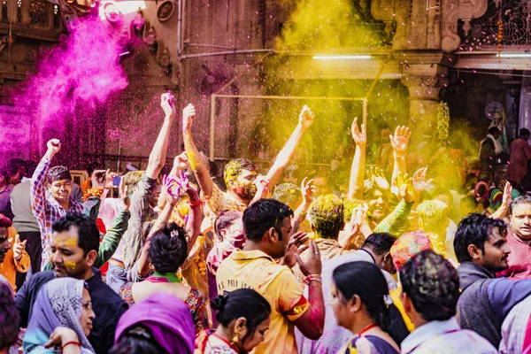 Barsana, India - 23 de febrero de 2018 - La multitud irrumpe en risas y bailes mientras la pintura en polvo se lanza al aire durante el festival Holi —  Fotos de Stock