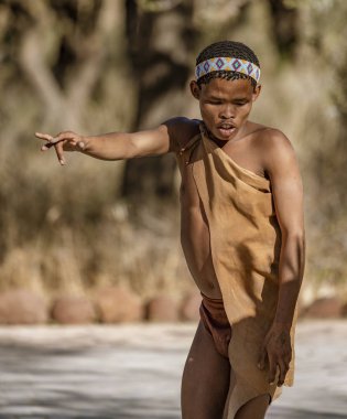 Erindi, Namibya - 19 Temmuz 2018: Yerli bir bushman fotoğrafçılara iyi avlanmak için veda dansı yapıyor