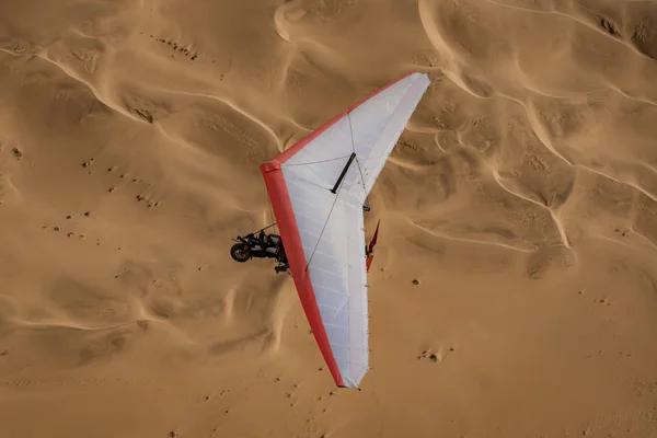 Walvis Bay, Namibia - 16 luglio 2018: un aereo ultraleggero è visto volare con dune di sabbia come sfondo — Foto Stock