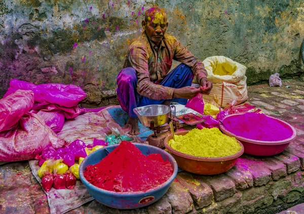 Barsana, India - February 23, 2018 - A man sells paint powder to be thrown by revelers in Holi festival — Stock Photo, Image