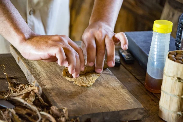 Man demonstreert hoe je een perfecte Cubaanse sigaar rolt — Stockfoto