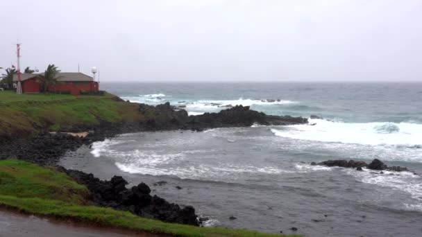 Vuelta de olas en la costa rocosa con estación meteorológica en la costa — Vídeos de Stock