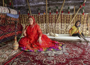 Shiraz, İran - 2019-04-09 - Kazgal kadını çadırında su borusu nargile içiyor