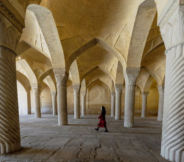 伊朗设拉子（英语：Shiraz, Iran）- 2019-04-08年-妇女穿过Vakil清真寺凹凸不平的柱子 — 图库照片