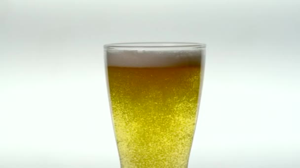 Bicchiere di birra Ale pallido a movimento lento - Bolle sorgono sotto schiuma su vetro rotante — Video Stock