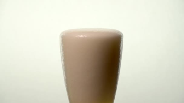 Verre à bière pâle à mouvement lent - La mousse se répand sur le côté jusqu'à ce que la bière monte 