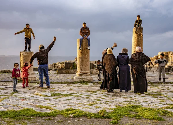 Jerash, jordan - 2019-04-19 - Jungen stehen auf einer Säule einer 2000 Jahre alten römischen Ruine, während ihre Familien Fotos machen — Stockfoto