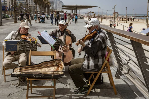 Tel Aviv, Israel - 2019-04-27 - Trio de cordas composto por homens idosos brincam no calçadão da praia — Fotografia de Stock