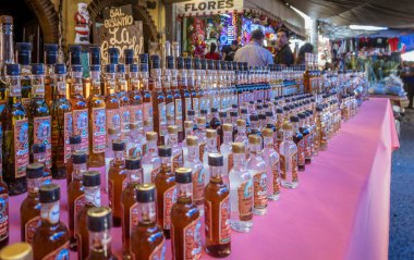 Oaxaca, Meksika - 2019-11-30 Mezcal marketteki içki standına dizildi.