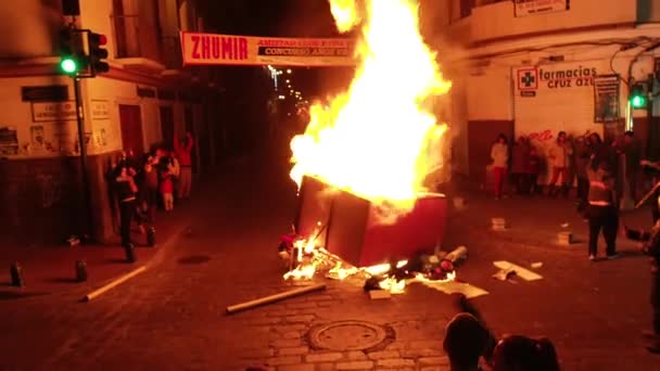 Cuenca, Ecuador - 31 de diciembre de 2018 - La hoguera se alimenta en la calle a medianoche en la víspera de Año Nuevo mientras la gente se abraza y celebra — Vídeo de stock