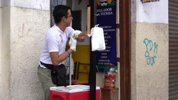 Cuenca, Ecuador - December 31, 2018 - Man makes salt water taffy and sells to a woman customer — Stock Video