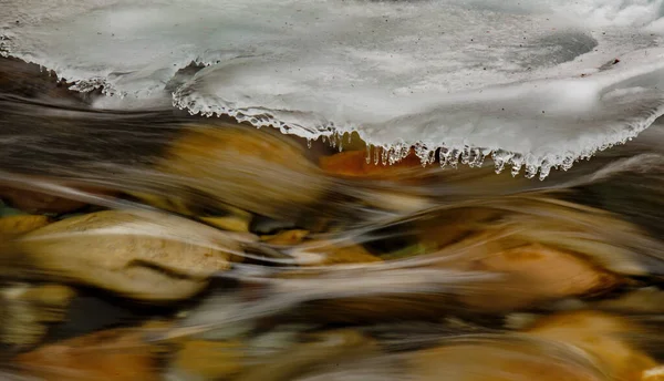 Nehir hızla büyüyen buz tabakasının altından akar. — Stok fotoğraf