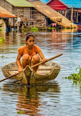Tonle Sap gölünde kürek çeken bir kız.