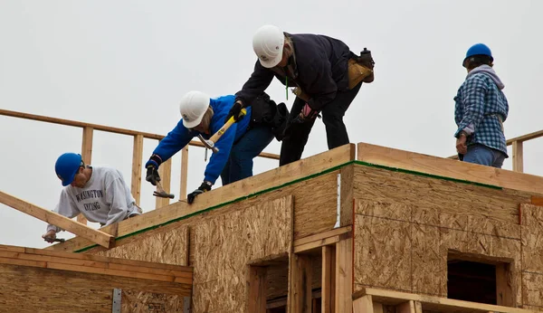 Oakland, Calif - Jan 8, 2011: Volunteers help to build new homes for the poor — Stock Photo, Image