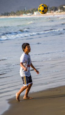Puerto Lopez, Ekvador - 19 Ağustos 2016 - Çocuk plajda futbol oynuyor