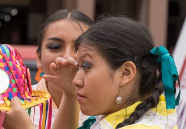 Cuenca, Ekvador - 25 Şubat 2017: Genç kadın Orquidea geçit töreni için makyajını hazırlıyor